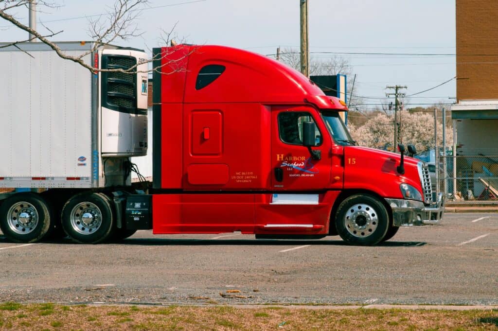 Red semi-truck on highway showing trucking career