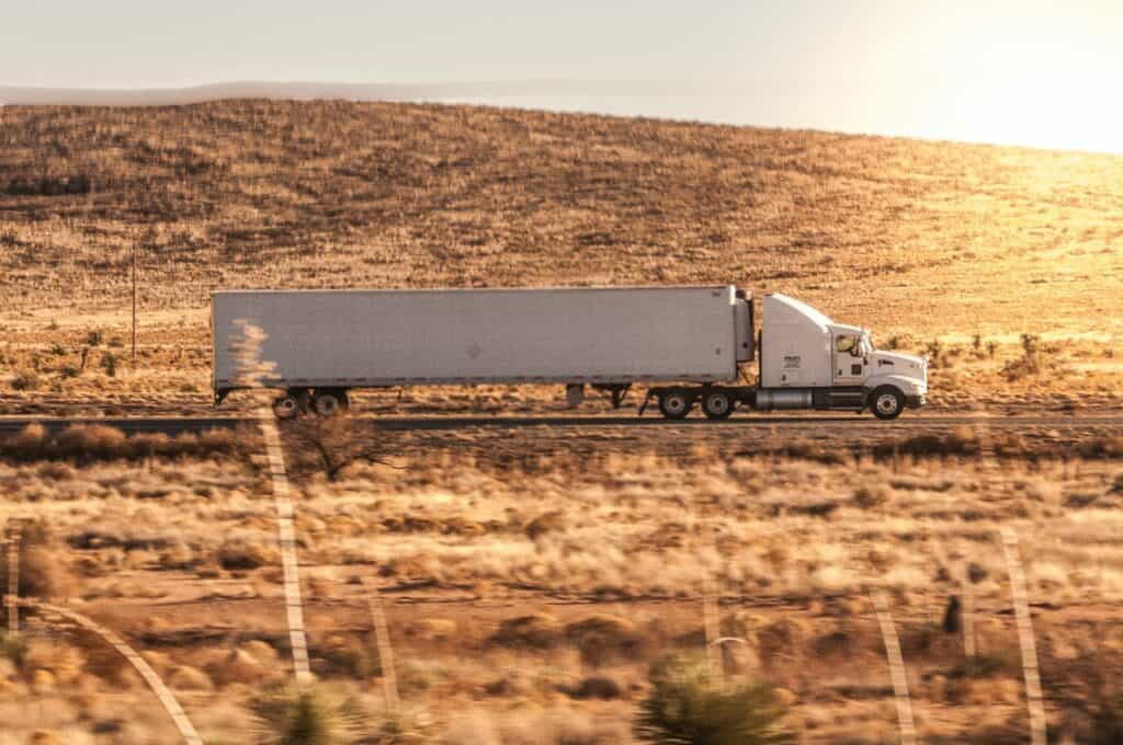 "A truck travels down a remote American highway, depicting the lonely and harsh life of 'The Life of a Truck Driver in the USA.'