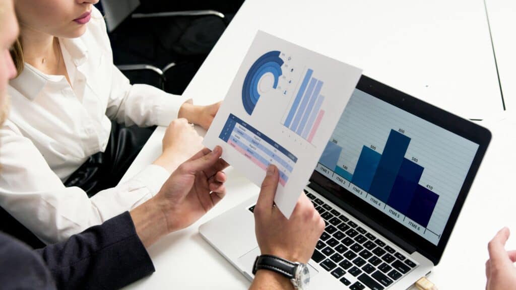 Graduates review loan options and charts for student loan management tips.