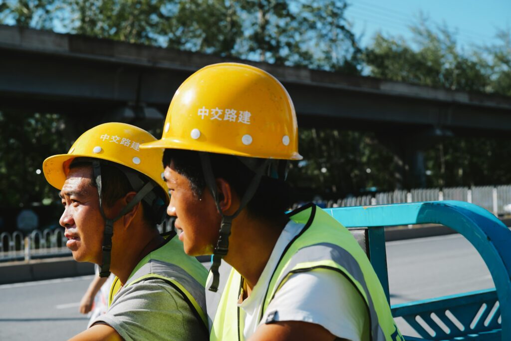 Workers wearing yellow helmets, who are managing their student loan debt by doing part-time jobs.