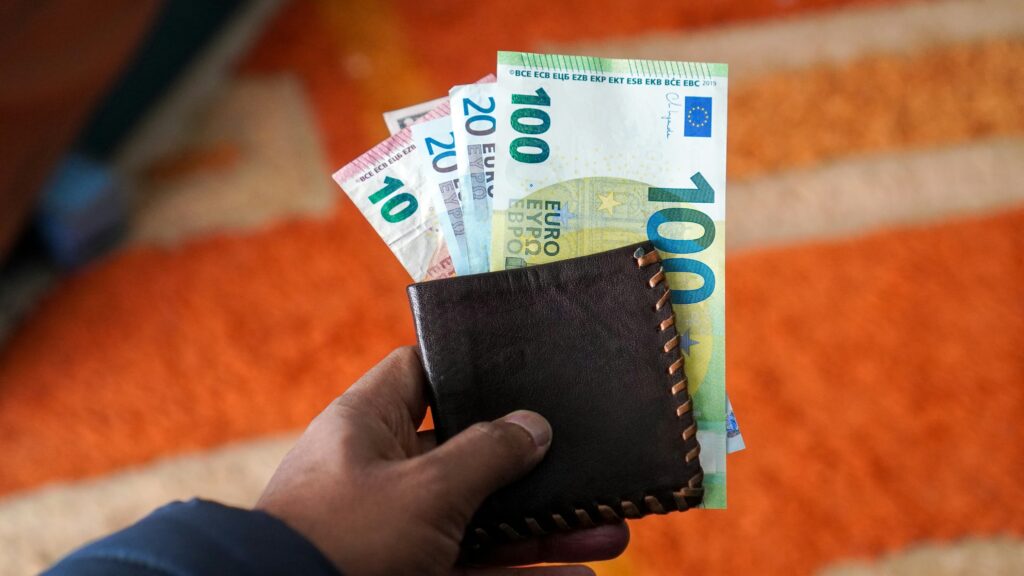 Money in the wallet that is being used for student loan debt payment.